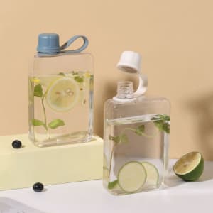 A drink bottle in clear plastic with a blue lid and a white lid, filled with water and garnished with lime and mint.