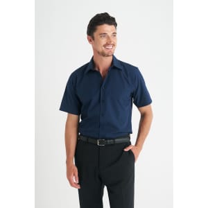 A navy blue short sleeve button-up shirt with a structured collar, paired with black trousers. The model is smiling.