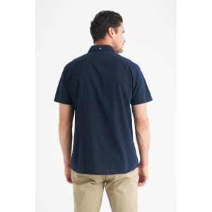 A navy short sleeve button-up shirt with a collar, featuring a back view of a model.