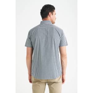 A man wearing a short sleeve button-up shirt with a checkered pattern in navy and white, viewed from the back.