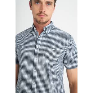 A short-sleeved button-up shirt featuring a black and white check pattern, with a collar and a logo.