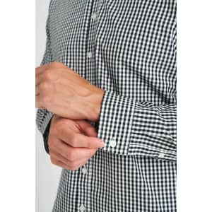 A close-up of a black and white checked long sleeve button-up shirt with white buttons.