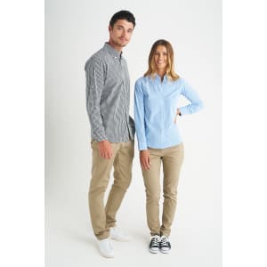 A man and woman model stylish button-up shirts in check and striped patterns, paired with beige pants and casual shoes.