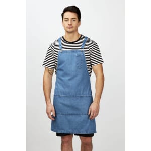 A man wearing a striped black and white T-shirt under a denim apron, standing against a plain background.