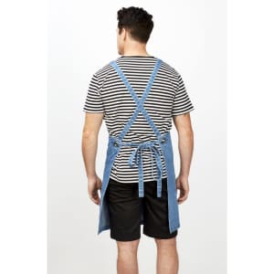 A striped men's T-shirt worn under a denim apron, showcasing the back and straps. The outfit includes black shorts.
