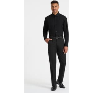 A black long sleeve button-up shirt displayed on a male model, paired with black trousers and shoes.