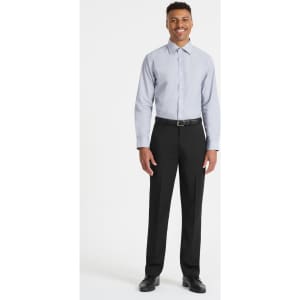 A man stands wearing a light blue long sleeve button-up shirt paired with black trousers and shoes. The shirt features a logo.