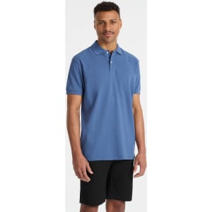 A young man wearing a blue polo shirt paired with black shorts, featuring a small logo.