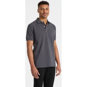 A men's polo shirt in grey, featuring a collar and short sleeves, displayed on a model. The shirt includes a logo.