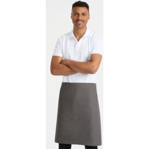 A man wearing a grey waist apron over a white polo shirt, standing with arms crossed. The apron features a front pocket.