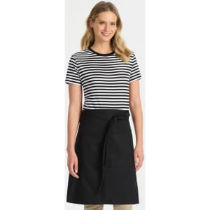 A woman wearing a black and white striped t-shirt paired with a black apron, smiling against a plain background.