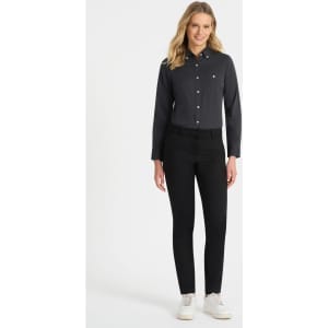A black ladies long sleeve button-up shirt displayed on a model, paired with black pants and white sneakers.