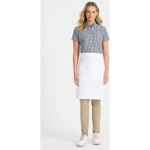 A woman wearing a checked shirt and a white waist apron stands against a plain background. The apron features a logo.