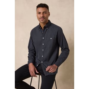 A men's long sleeve button-up shirt in dark grey with a subtle pattern and a branded logo.