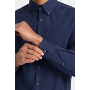A dark navy men's long sleeve button-up shirt featuring a neat collar and button detail on the cuffs.