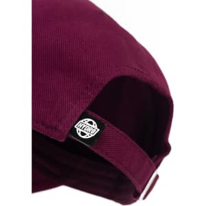 A maroon cap with a branded label on the side, featuring a curved peak and adjustable strap.