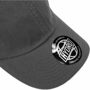 A grey cap featuring a circular logo and a curved brim, designed as premium headwear.