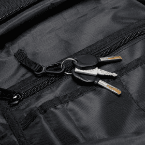 A black backpack interior with a keyring holding two silver keys. The backpack has multiple zippered compartments.