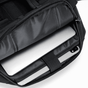 A black backpack with a zippered compartment containing a laptop and an iPad inside.