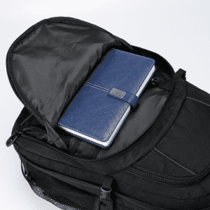 A black Fitzroy backpack with a blue notebook inside the main compartment and a textured finish.