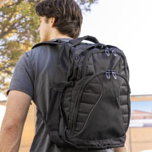 A black Fitzroy Backpack with multiple compartments and zippers, worn on the back of a person.