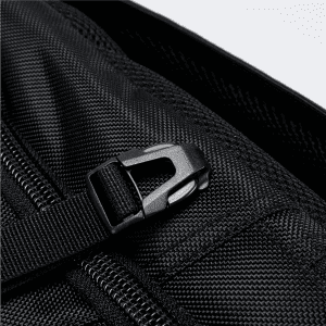 A close-up of a black Eiger Backpack showcasing a zipper and strap detail. It has a logo on the fabric.