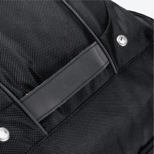 A close-up of a black Eiger backpack featuring textured fabric and a rectangular panel. It has a logo.