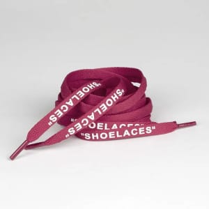 Burgundy printed shoelaces, featuring white text, neatly coiled in a loose spiral arrangement.