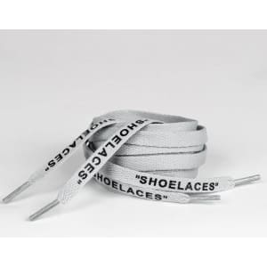 A pair of grey shoelaces featuring the word "SHOELACES" printed along their length, with metal tips at the ends.
