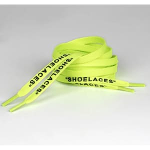 A pair of bright neon yellow shoelaces with printed text along the length.