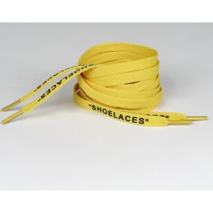 A pair of yellow shoelaces with black text on the ends, coiled neatly on a neutral background.