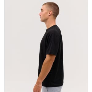 A black Core Tee displayed on a model, showcasing its side profile against a plain background.