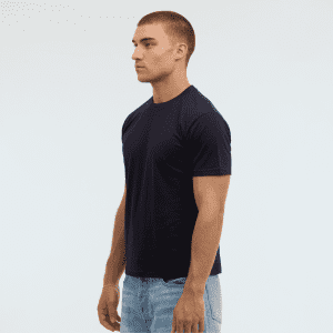 A man wearing a navy blue t-shirt stands in profile against a plain background. The shirt features a logo.