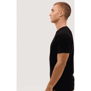 A black t-shirt is displayed on a model, shown from the side profile against a plain background.
