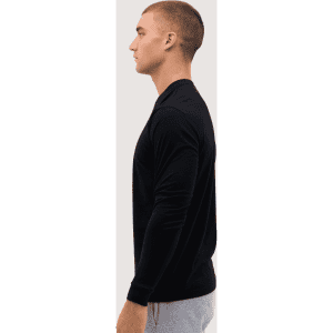 A long sleeve tee in black, featured on a model in profile view, showcasing a simple and sleek design.