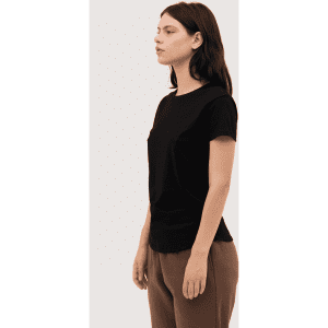 A black women's essential tee is displayed on a model, showcasing a simple, fitted design.
