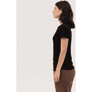 A women's essential tee in black, featuring a fitted design and short sleeves, displayed on a model from the side.