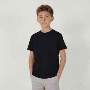 A youth essential tee in black, featuring a classic crew neck design. The model is standing with hands in pockets.