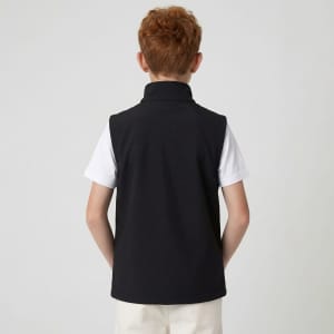 A black youth softshell vest with a high collar, worn over a white shirt, seen from the back.