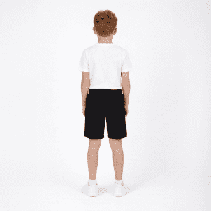 Youth Core Shorts in black showcased on a model wearing a white t-shirt, viewed from the back. Contains branding.