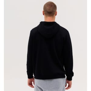 A black zip hood with a hooded design, viewed from the back, worn over grey pants. It has a logo on the clothing.