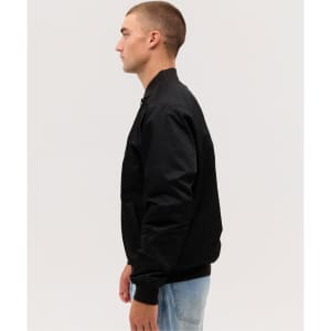A black bomber jacket is displayed on a model viewed from the side, showcasing its sleek design and fit.