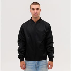 A black bomber jacket is displayed on a model, featuring a zip front and ribbed cuffs.