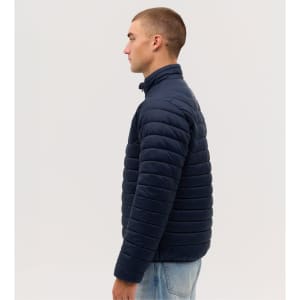 A navy blue puffer jacket, featuring a high collar and a quilted design, displayed on a model from the side.