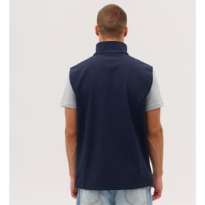 A navy softshell vest is displayed on a model from the back, featuring a high collar and no visible logos.