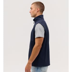 A side view of a navy blue softshell vest with a high collar, worn over a grey T-shirt.