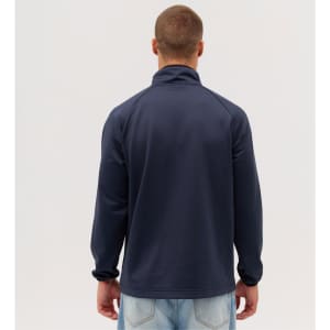 A navy jacket with a high collar, worn backwards by a person, featuring a logo on the back.