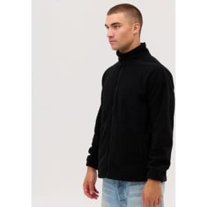 A man stands wearing a black polar fleece full zip jacket, featuring a zip closure and side pockets.