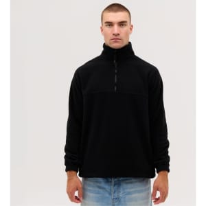 A black fleece 1/4 zip top on a model, featuring a high collar and long sleeves. There is a logo on the garment.