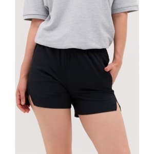 Black running shorts with side slits, featuring an elastic waistband and pockets. The model is wearing a grey top.